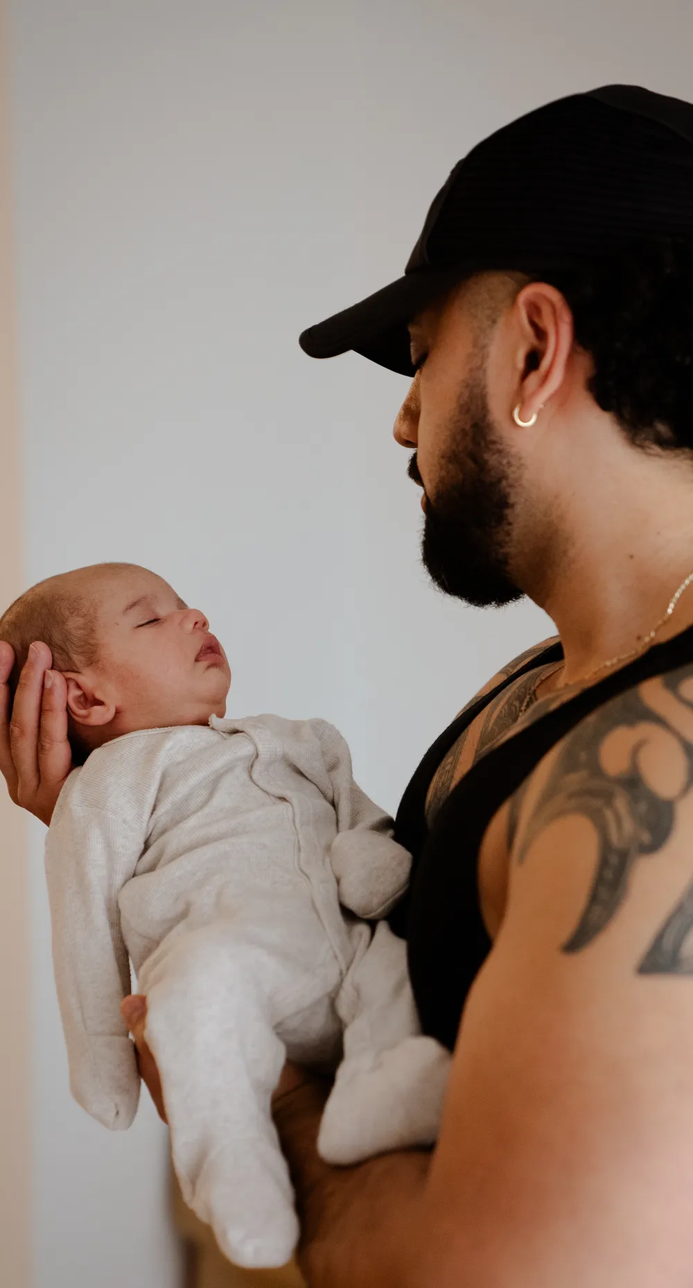 A father holding his sleeping pēpi